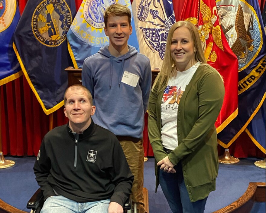 Sgt. Corey Briest (left) poses with his son Connor and wife Jenny, as Connor joins the South Dakota Army National Guard in Sioux Falls, March 11, 2022.