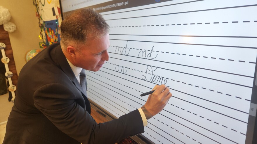 State Rep. Dane Watro signs his name on the board in Diane Mussoline’s classroom at Valley Elementary/Middle School.