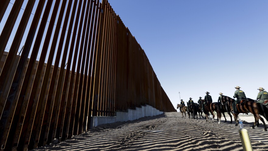 Mounted Border Patrol agents ride along a newly fortified border wall structure in Calexico, Calif. Funding for the border wall is one of a number of administration priorities that may face challenges if the Democrats flip the House.