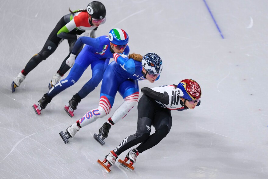 Athletes compete during a short track speed skating women's 1500 meters semifinal at the 2026 Winter Olympics, in Milan, Italy, Friday, Feb. 20, 2026. Corrine Stoddard can be seen with the number 3 on her helmet in second place.
