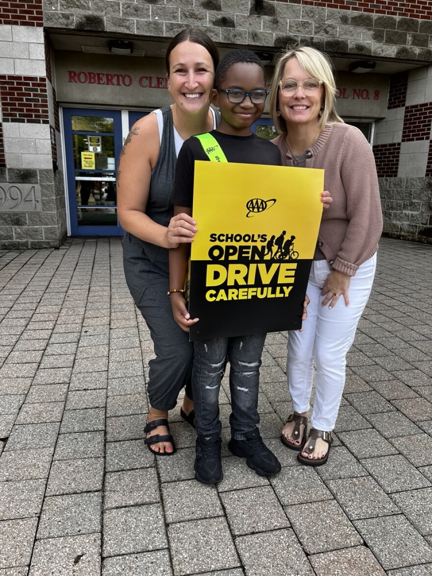 School No. 8 fifth grader Ti'Von Smith, a participant in the AAA School Safety Patrol program, stands between teacher Gina Roselli (left) and principal Eileen Kalbfus (right).
