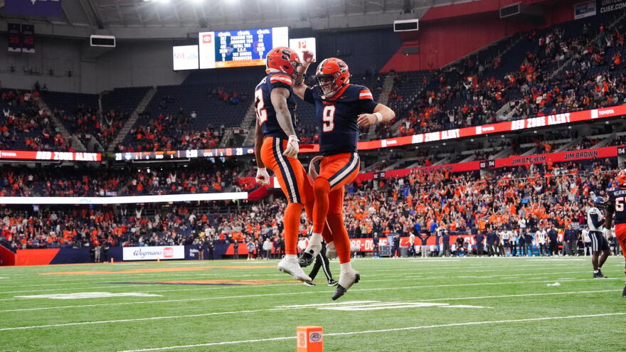Steve Angeli (9, blue) and Justus Ross-Simmons (12, blue) celebrate in Syracuse's 27-20 overtime win over UConn last season.