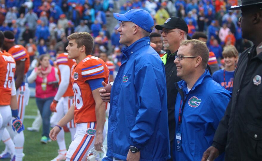 Coach Duke holds the game ball as he makes his way to the trophy ceremony at mid-field.