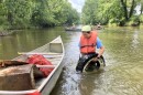Pictured here - a volunteer helps with river cleanups that have helped remove an estimated 20,000 pounds of trash from Ohio waterways this year.