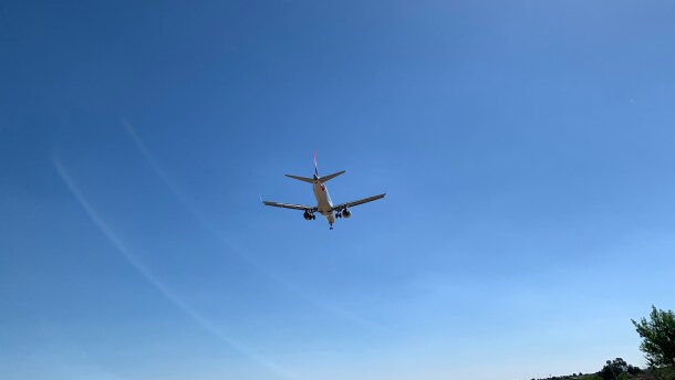 plane flies in blue sky
