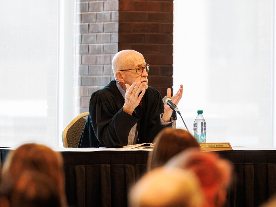 A judge gestures while on the bench during a hearing