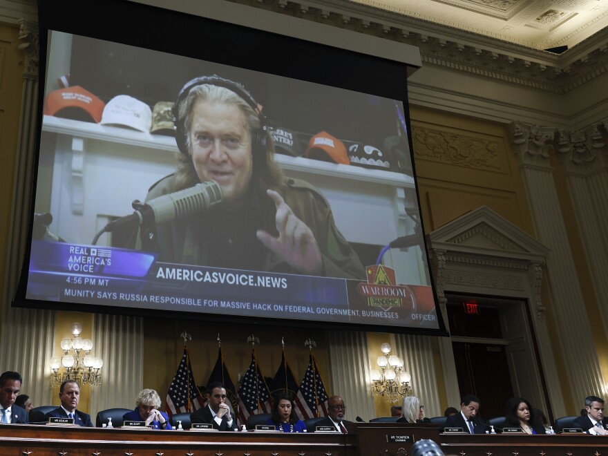 Steve Bannon, who was chief strategist for former President Donald Trump, appears on a video screen above members of the House committee that's investigating the Jan. 6, 2021, attack on the U.S. Capitol, during a hearing on July 12. [Anna Moneymaker / Getty Images]