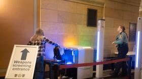 A visitor to the Minnesota State Capitol places a backpack into a scanner on Feb. 19, 2026. New in 2026, visitors are required to go through metal detectors.