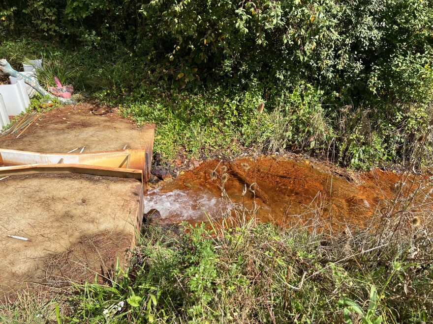 Toxic orange sludge seeps out of a former coal mine in Millfield. Rural Action has started removing the iron oxide from the creek.