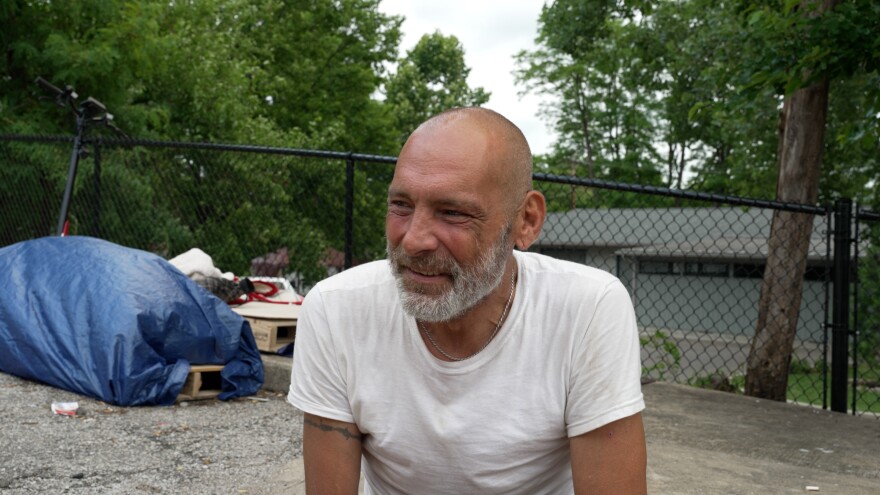 Sammy Carroll sits on a sidewalk near Wheeler Missions where he has stayed for nearly three years. Senate Enrolled Act 285 means he might have to move on Wednesday.