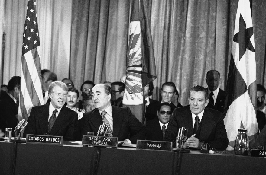 Then U.S. President Jimmy Carter (left) at the Pan American Union in Washington D.C., signing the Panama Canal treaty on Sept. 7, 1977, with Organization of American States Secretary-General Alejandro Orfila (center) and Panamanian head of government Omar Torrijos (right).