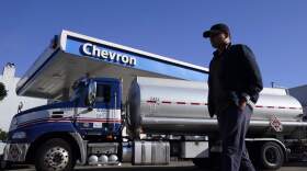 A pedestrian walks past a tanker at a Chevron gas station. (Jeff Chiu/AP)