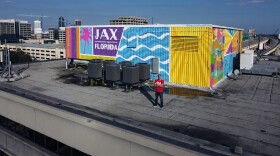 Jacksonville-based muralist Jason Tetlak poses with his latest art project.