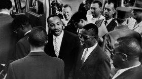 Dr. Martin Luther  King Jr. sees off a group of Freedom Riders as they board a bus for Jackson, Miss., on May 24, 1961.