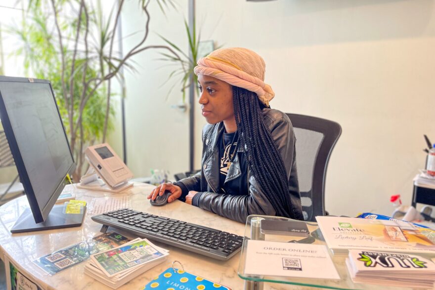 Dierra Henderson, a budtender at Luxury Leaf dispensary in St. Louis, checks in clients at the front door.