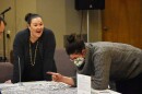 Two people converse while leaning over a table where a map of the GAP neighborhood is laid out.