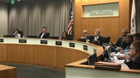 Council members sit at a dais.
