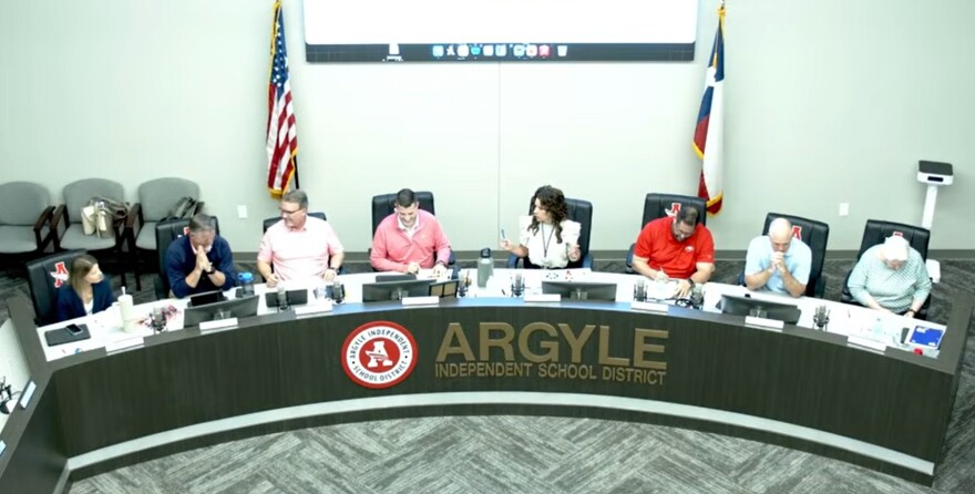 Adults sitting at a long school board meeting table