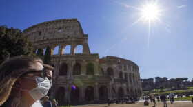 Tourists wearing face masks walk past the ancient Colosseum, in Rome, Thursday, March 5, 2020. Italy's virus outbreak has been concentrated in the northern region of Lombardy, but fears over how the virus is spreading inside and outside the country has prompted the government to close all schools and Universities nationwide for two weeks. (AP Photo/Andrew Medichini)