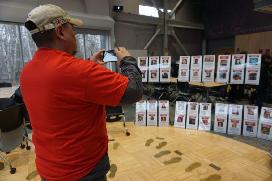 Scotty Barr, father of Ashley Johnson-Barr, takes a photo on April 30, 2026, of the lined-up posters of missing and murdered Indigenous Alaskans. His daughter is among the featured victims. She was 10 years old when she was abducted and killed in Kotzebue in 2018. The photos were displayed at the third annual Walk for Missing and Murdered Indigenous People, hosted by the Alaska Native Science and Engineering Program at the University of Alaska Anchorage.