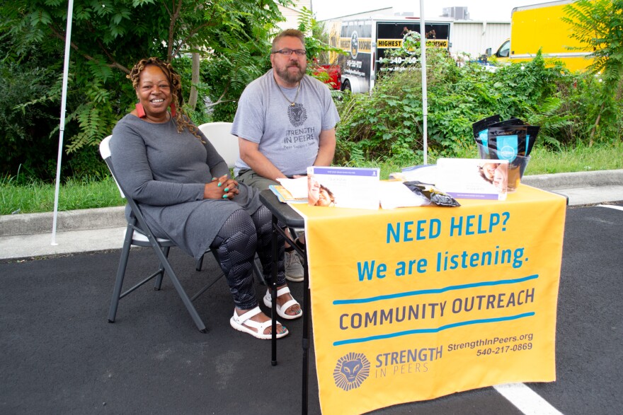 Deborah Mason, left, and Frank Pilkerton sit in the parking lot outside an opioid addiction treatment center.