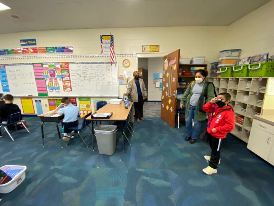 Principal Allana-Rae Ramkissoon (at doorway) gives Milagros Macher and her son, Alberto, a tour of Our Lady of the Assumption Catholic School.