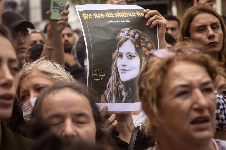 People hold signs and chant slogans outside the Iranian Consulate in Istanbul, Turkey, on Wednesday during a protest over the death of Iranian Mahsa Amini.