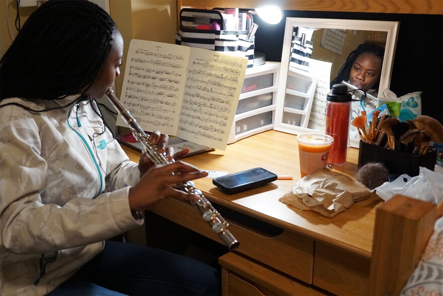 Ngone practices the flute inside her dorm room.