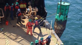 U.S. Coast Guard crew sets a replacement buoy from the Cutter Cypress.