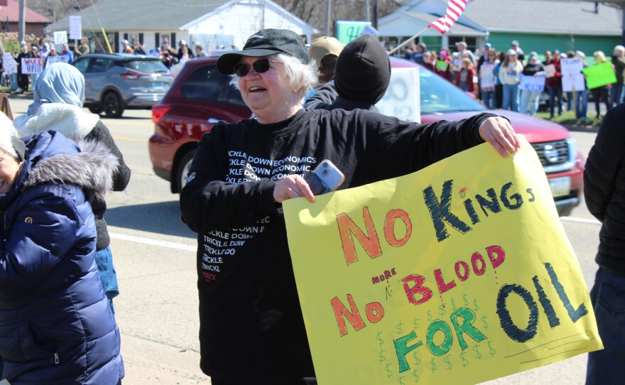 J. Gruber of Peoria Heights holds a sign that reads "No Kings, No More Blood For Oil."