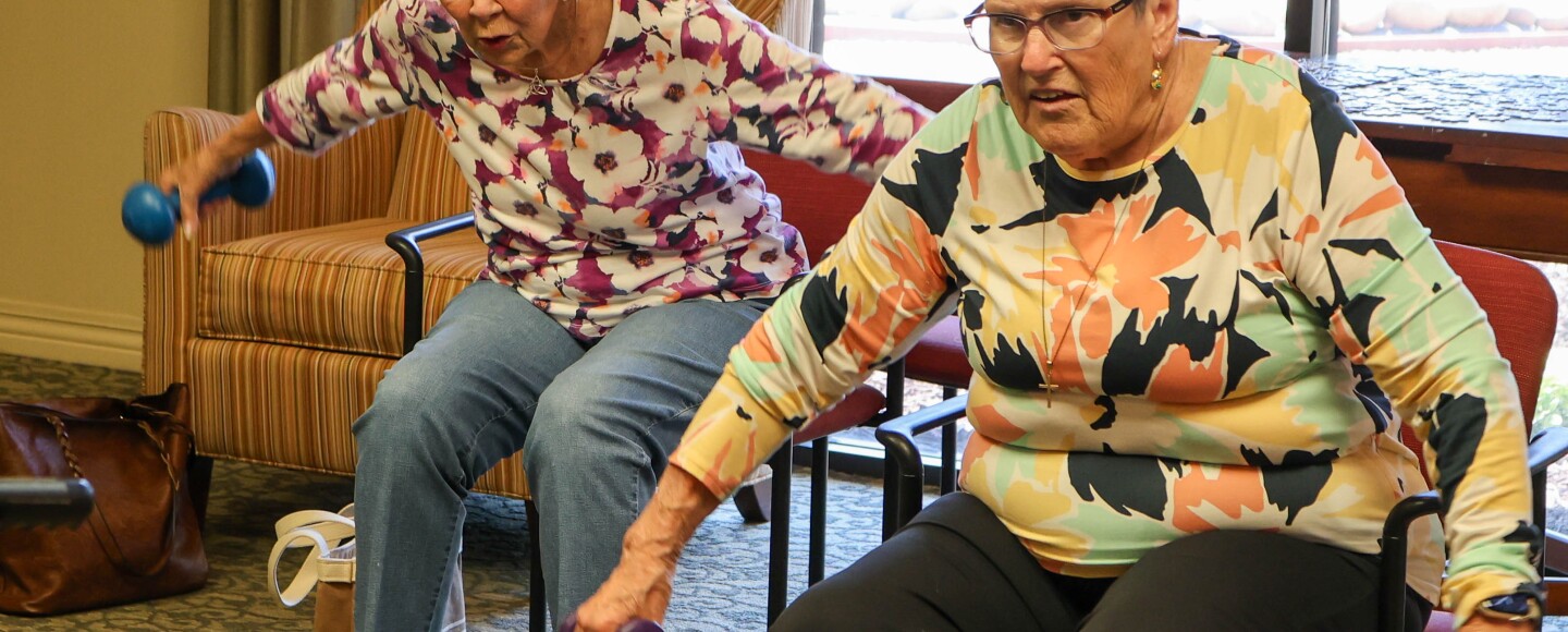 Older adults including Mady Montague, right, lift dumbbells during an “Injury and Fall Prevention” class offered by Merced College at an assisted living home in the city.