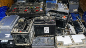 Pallet with used car batteries waiting to be recycled in an environmentally harmful scrap yard