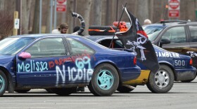  A crappy blue sedan with graffittii and a pirate flag, ready to rock for the Gambler 500