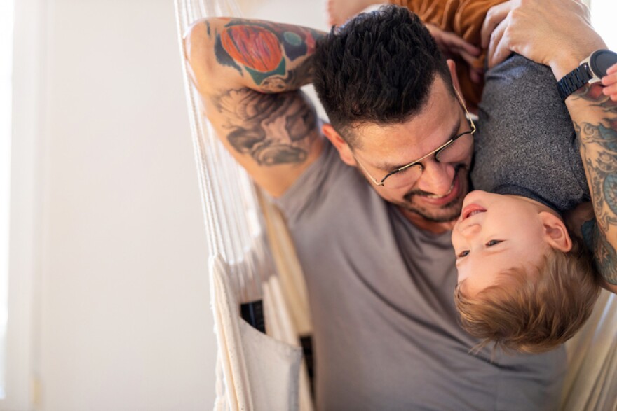 Father and baby son having fun together at home