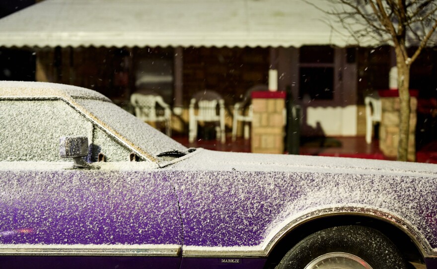 Snow covers a classic car in downtown Raleigh.
