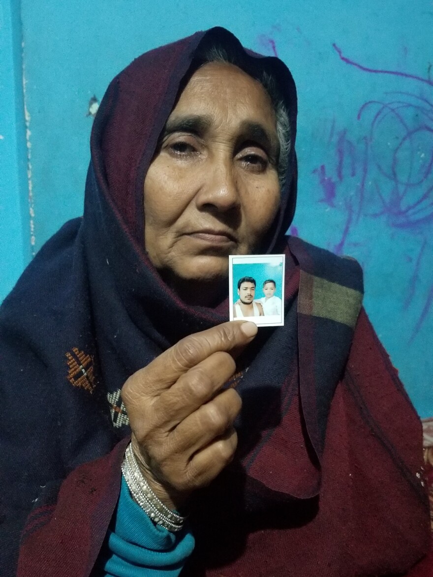 Nafisa, who goes by one name, holds a photo of her son Mohammed Mohsin with his son, now four years old. Mohsin was shot dead last month outside the family's home in Meerut.