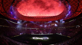 Fireworks go off as Lionel Messi of Argentina lifts the FIFA World Cup Trophy after the team's victory during the FIFA World Cup Qatar 2022 Final match between Argentina and France at Lusail Stadium in Lusail City, Qatar.