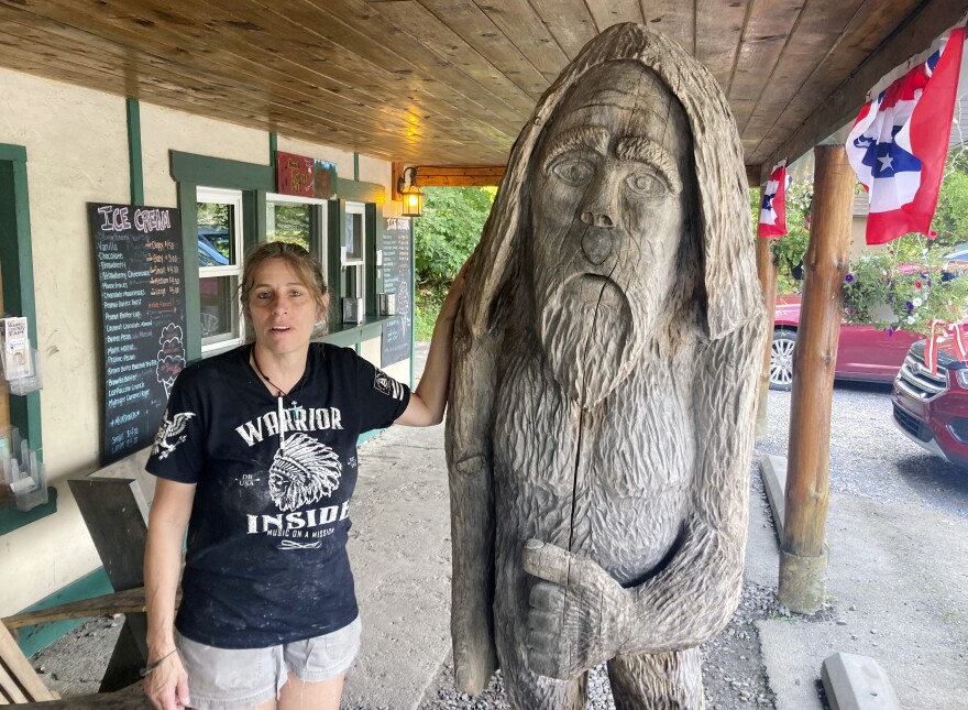 Pauline Bauer leans against a wooden statue outside Bob's Trading Post, her restaurant in Hamilton, Pa., July 21, 2021. A federal judge has convicted a Bauer of storming the U.S. Capitol, where she screamed at police officers to bring out then-House Speaker Nancy Pelosi so the pro-Trump mob could hang her.