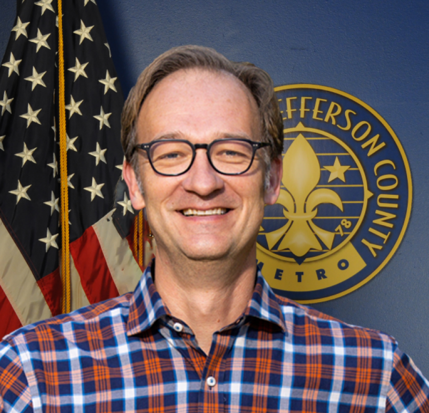 Metro Council Member Andrew Owen poses for a photo in a red, blue and white checkered shirt and black glasses