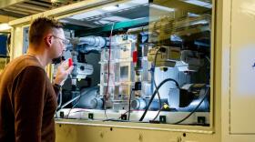 An employee examines a vanadium flow battery stack in the Battery Reliability Test Laboratory at PNNL.