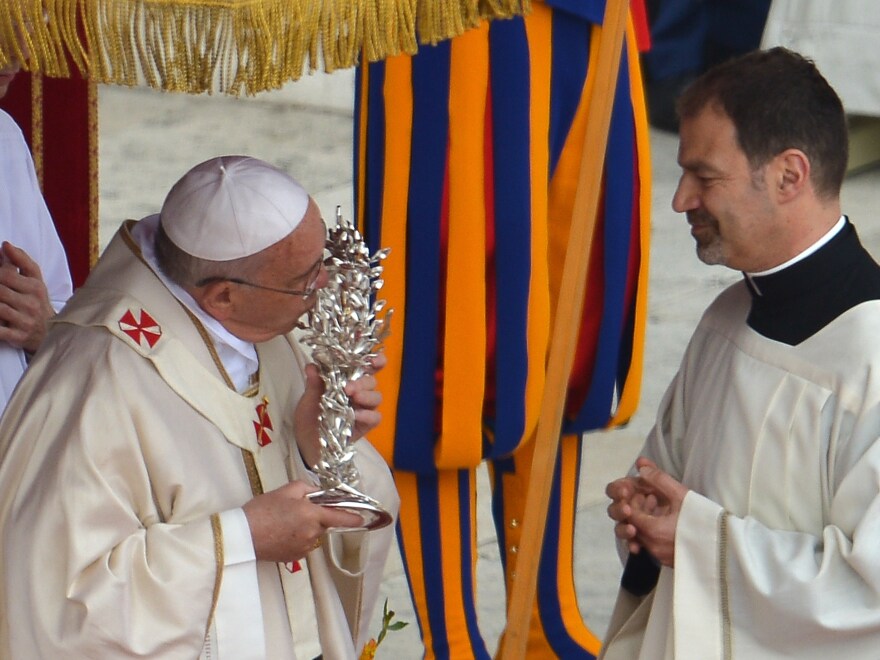 Pope Francis kisses the relic of Pope John XXIII during the canonization mass.