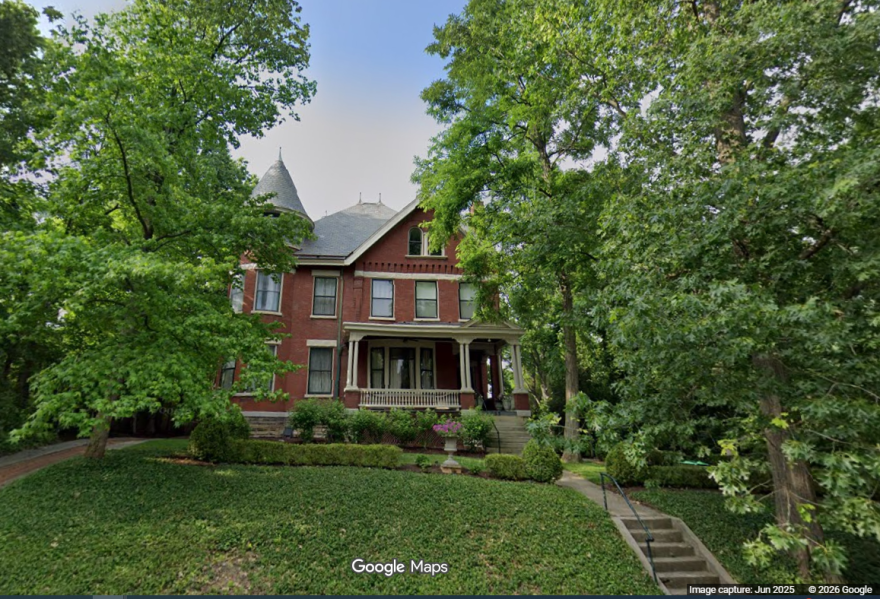A brick home with a front porch and turret