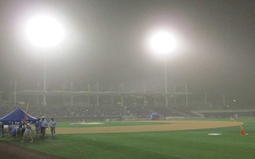 A monsoon sweeps across the baseball stadium, canceling the Light Up the Sky fireworks display.