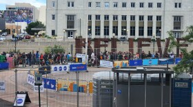 A large group of people can be seen standing in line behind the set up of Rollin' Reno