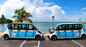 Two small three-door vehicles plastered with St. Pete Beach logos and messaging.