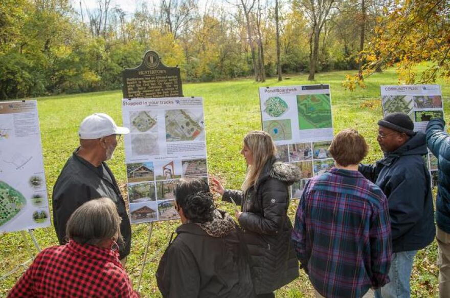 A group of students show their design proposals to community leaders.