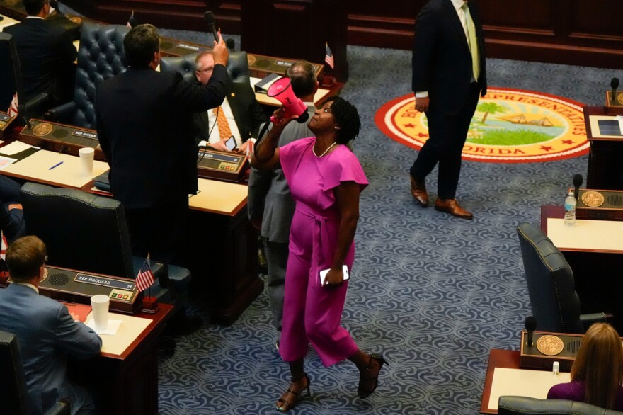 State Rep. Angie Nixon, D-Jacksonville, shouts through a megaphone on the House floor in protest of a vote on a redistricting bill during a special session of the Legislature, Wednesday, April 29, 2026, in Tallahassee. The House Rules and Ethics Committee later reprimanded Nixon for the disruption.