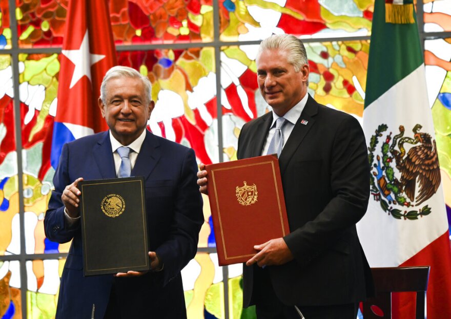 Cuban president Miguel Diaz Canel and his Mexican counterpart Andrés Manuel López Obrador show the signed bilateral agreements at the Revolution Palace in Havana, Cuba, Sunday, May 8, 2022. (Yamil Lage/Pool Photo via AP)