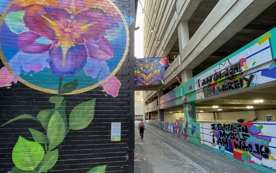 A person walks through the art-filled "Luminous Lane" in uptown Charlotte on April 3, 2024.