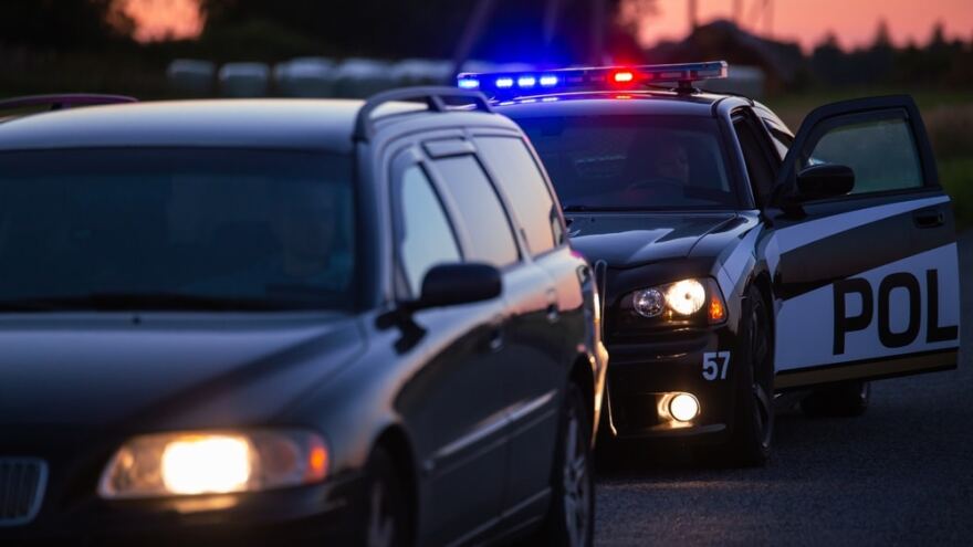 nighttime police traffic stop in with police car with lights on 